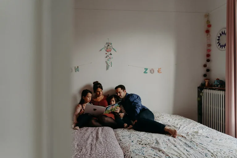 photographe famille en moment lecture dans leur chambre