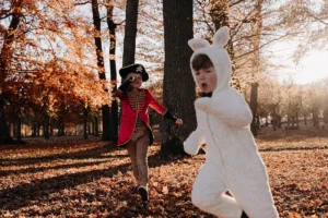 photographe famille de deux garçons déguisés qui courent dans la forêt
