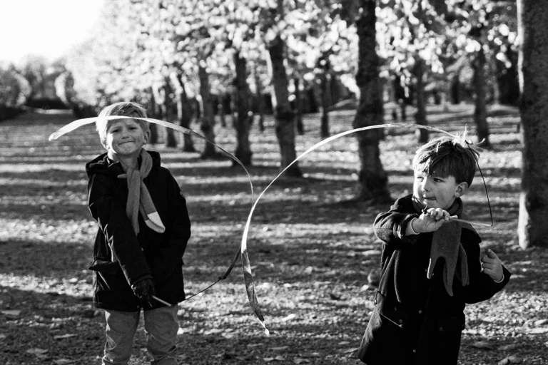 photographe famille de deux garçons qui jouent dans un parc