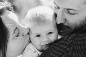 photographe bébé de parents faisant un bisou à leur bébé
