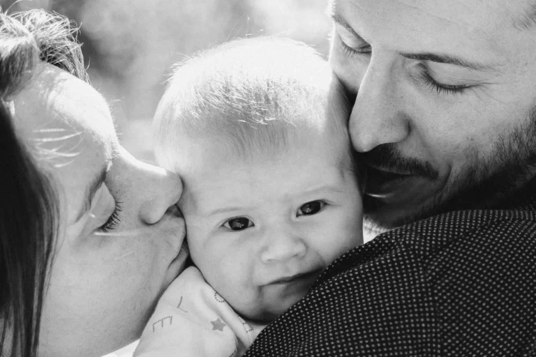 photographe bébé de parents faisant un bisou à leur bébé