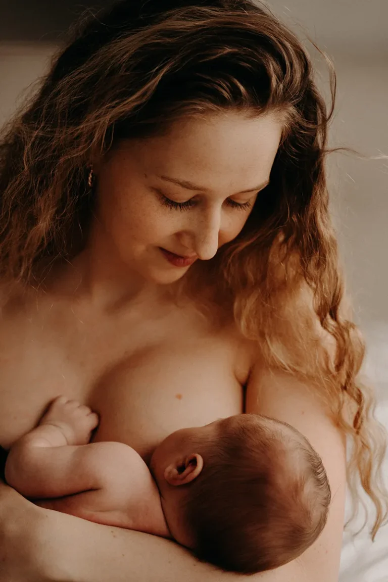 photographe bébé d'une mère qui regarde son nouveau né pendant l'allaitement