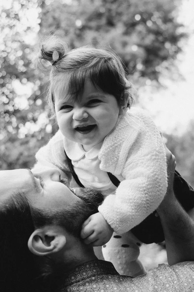 photographe bébé d'un père en forêt jouant à porter son bébé qui rit