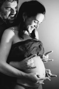 photographe grossesse de futurs parents rocks qui regardent le ventre nu de la femme enceinte