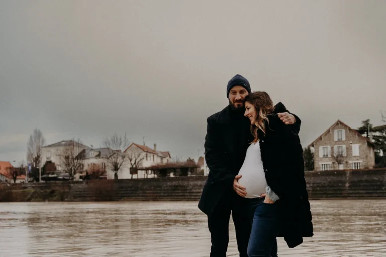 photographe grossesse à Paris en extérieur d'un homme qui caresse le ventre de sa femme enceinte