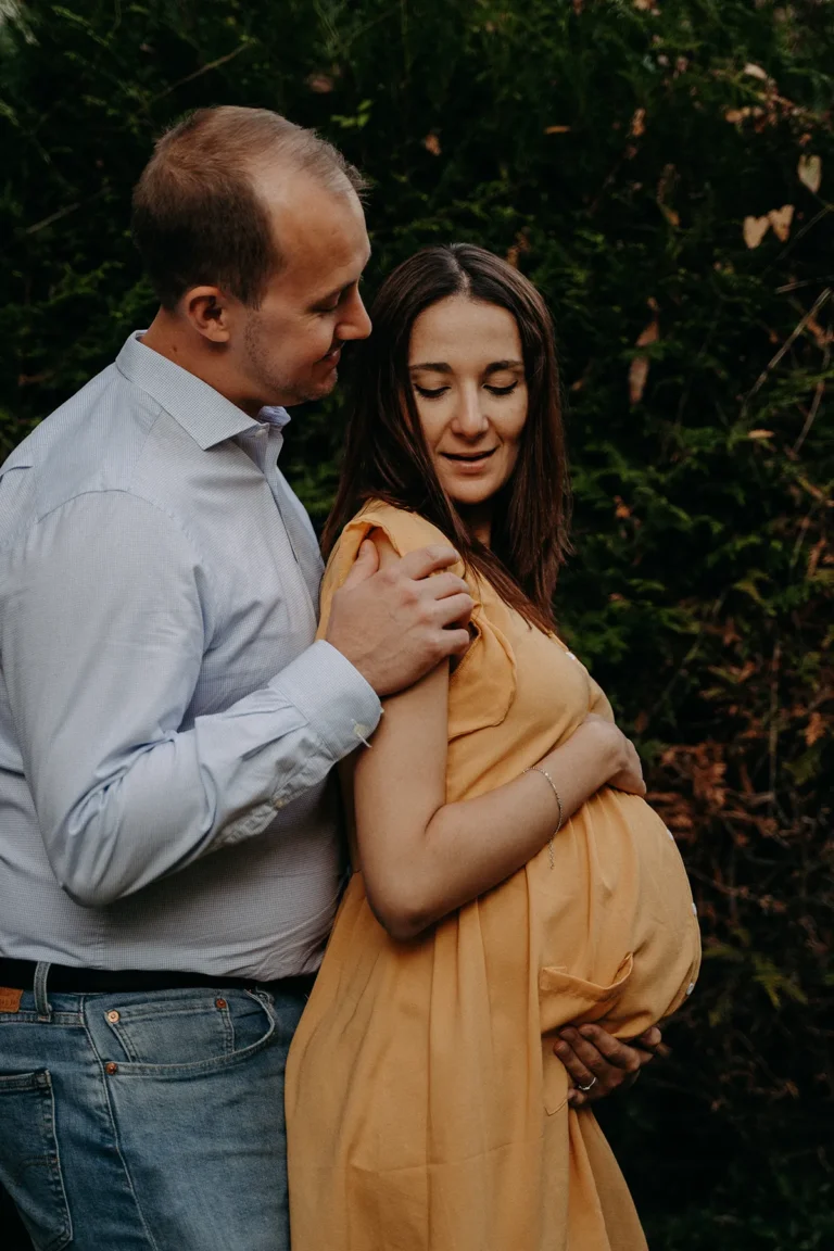 futurs parents enlacés avec amour en extérieur photographiés par une photographe grossesse à paris