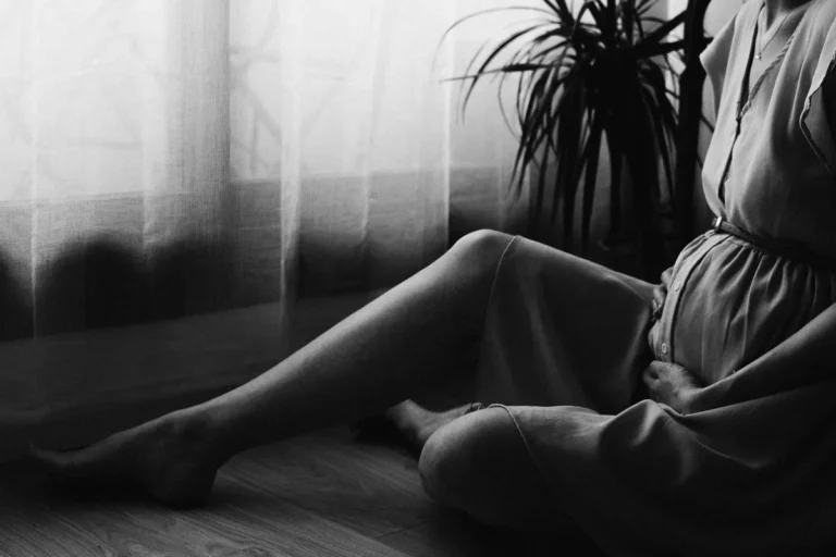 ventre d'une femme enceinte dans son salon à paris pendant une séance grossesse