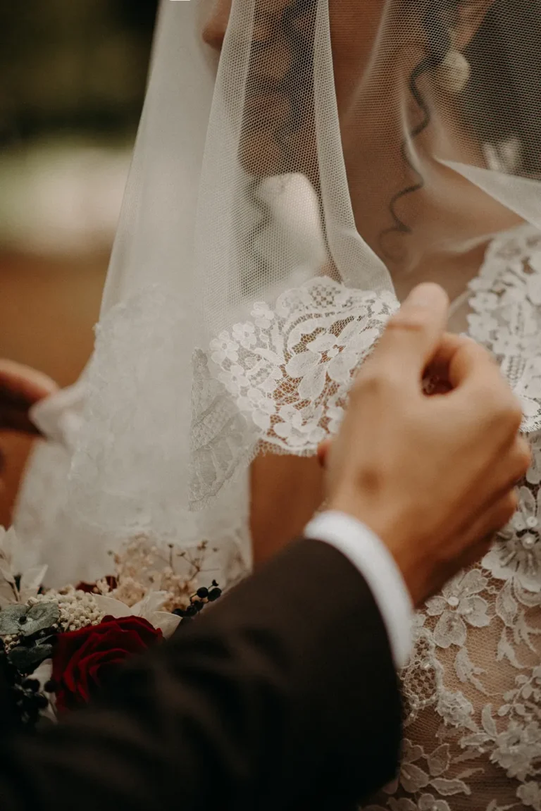 marié soulève le voile de sa femme photographiés par une photographe de mariage